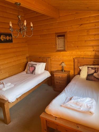 1 dormitorio con 2 camas en una cabaña de madera en The Fairways, Kenwick Retreats en Louth