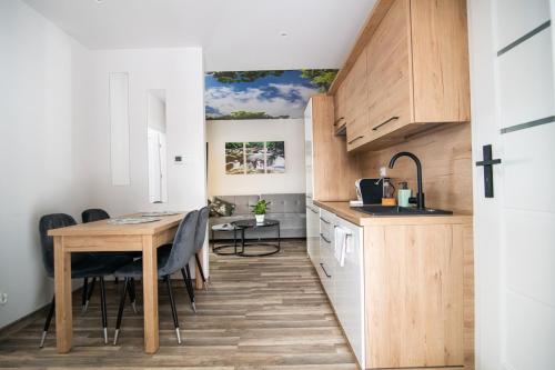 a kitchen and dining room with a table and chairs at Oliwne Wzgórza in Stronie Śląskie