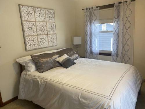 ein Bett mit zwei Kissen darauf in einem Schlafzimmer in der Unterkunft 4 Bedrooms~2 Baths Cute & Cozy, Excellent Location in Dubuque