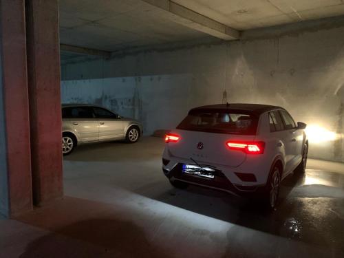 a white car parked in a parking garage at Klidi Apartment in Tirana