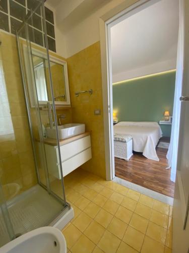 ein Bad mit einer Dusche, einem Waschbecken und einem Bett in der Unterkunft Mareluce in Letojanni