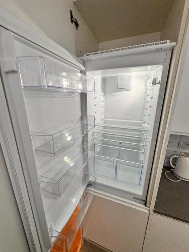 een lege koelkast met de deur open in een keuken bij Luxury 2 BHK in Canary Wharf in Londen