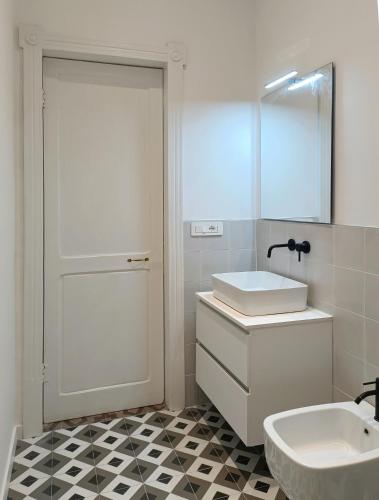 a white bathroom with a sink and a mirror at Noliday Savona Center Art Deco Apartment in Savona