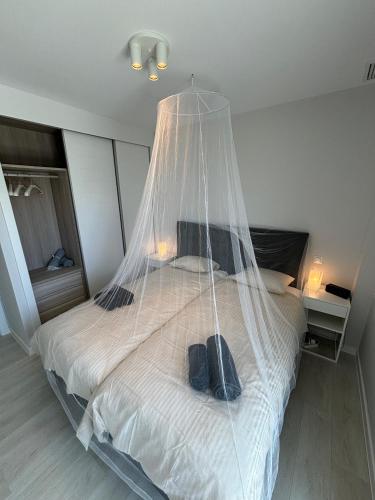 a bedroom with a bed with a net on it at New penthouse with sunny beach view in Huelva