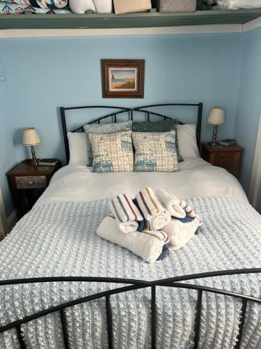 Una cama con dos toallas y dos animales de peluche. en Florita - Dawlish, en Dawlish