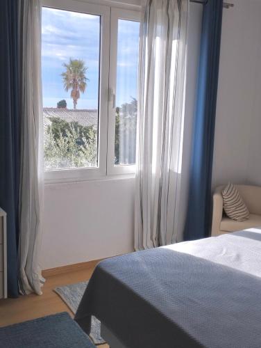 a bedroom with a window with a view of a palm tree at Guesthouse - Hotel California in Novalja