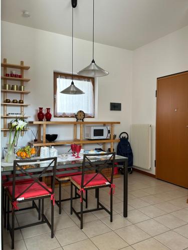 - une cuisine avec une table, des chaises et un four micro-ondes dans l'établissement Appartement GIUDECCA, à Venise