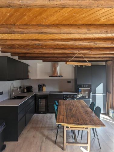 - une cuisine avec une table en bois et un plafond en bois dans l'établissement Appartement rénové proche centre ville navette 6-8 personnes multipass, à Châtel
