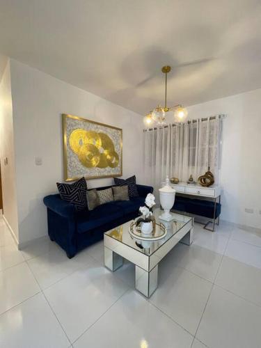 a living room with a blue couch and a table at Hermoso apartamento con piscina. in La Estrella