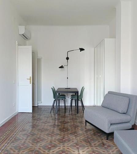 a living room with a table and a chair and a couch at Noliday Savona Center Art Deco Apartment in Savona
