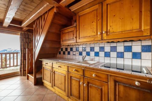 une cuisine avec des armoires en bois et un évier dans l'établissement Résidence Les Alpages de Chantel - maeva Home - Appartement duplex 3 Pièces 6 Personnes - Sélection MAE-1646, à Bourg-Saint-Maurice