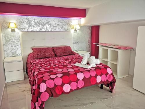 1 dormitorio con cama roja y colcha roja y blanca en OFIC/ESTUDIO CONIL S.A., en Conil de la Frontera