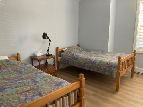 um quarto com duas camas e um candeeiro sobre uma mesa em Rustic Retreat em Lambton Shores