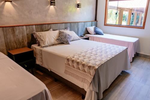 a bedroom with two beds and a window at Pousada Novo Prado in Prado