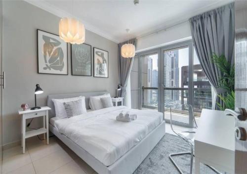 a white bedroom with a large bed and a large window at BEST OFFER! One Bedroom with Downtown Views in Dubai