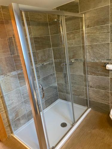 a shower with a glass door in a bathroom at The Fairways, Kenwick Retreats in Louth
