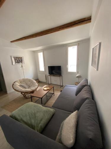 un salon avec un canapé et une télévision dans l'établissement Le Refuge du Port, parking privé gratuit, à La Ciotat