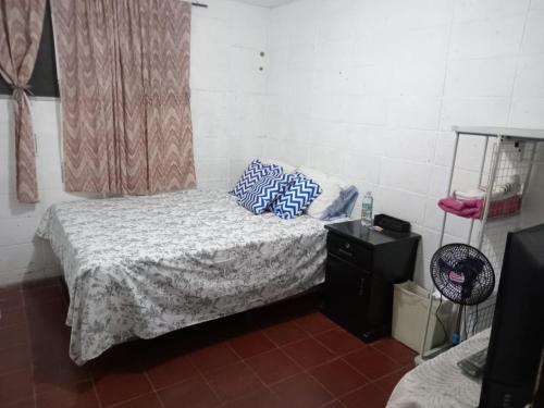 a bedroom with a bed with blue pillows on it at Santa Tecla Acogedora Guest House in Nueva San Salvador