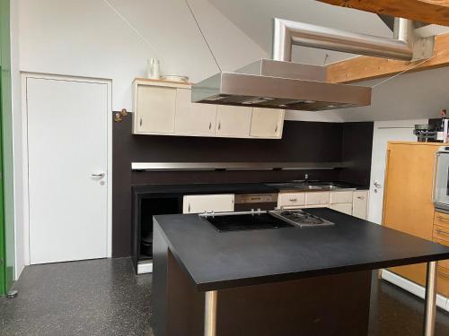 una cucina con piano di lavoro nero e piano cottura di Schlosserhaus a Lustenau