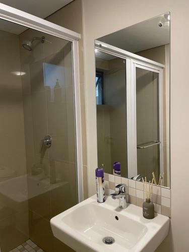 a bathroom sink with a shower and a mirror at Luxurious Millennium, uMhlanga Durban in Durban