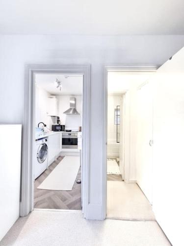a white kitchen with a washer and dryer at Fresh and Sparkling - Free Parking in Crystal Palace