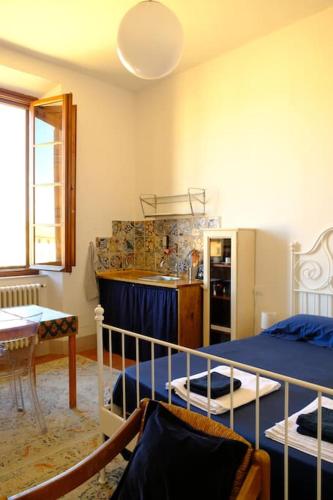 a bedroom with a bed and a kitchen with a refrigerator at Romantic Suite in Pisa