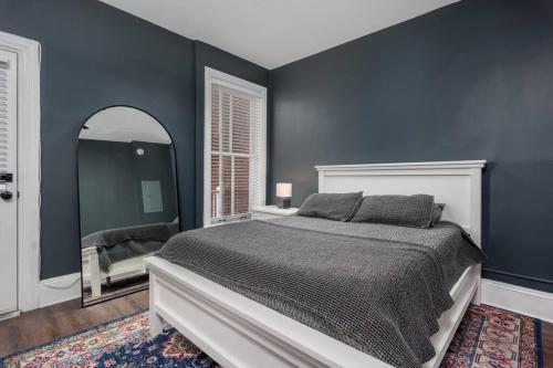 a bedroom with a large bed and a mirror at Flats on Front - Riverfront Gem Fast Wi-Fi 3F in Harrisburg