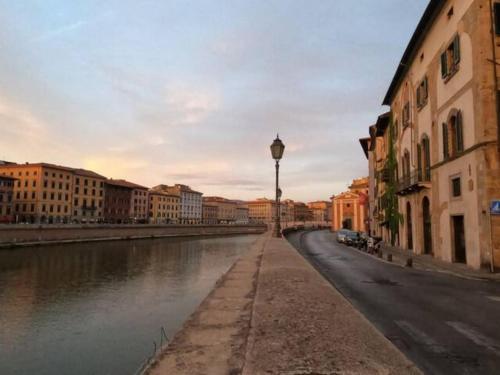 a view of a river in a city with buildings at Romantic Suite in Pisa