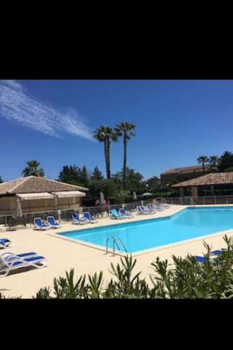 - une grande piscine avec des chaises et des personnes dans l'établissement Appartement dans résidence, à Linguizzetta