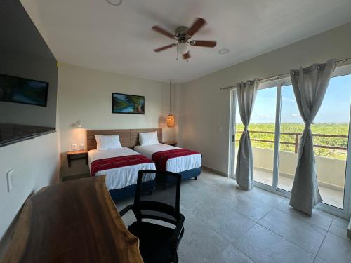 a hotel room with two beds and a window at Oneiro Suites with Sea View in Mahahual