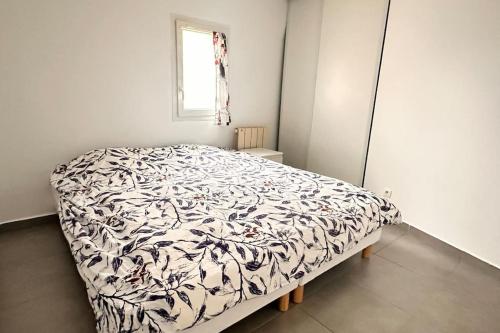 une chambre avec un lit avec une couverture noire et blanche dans l'établissement Bel appartement proche Paris et Disney, à Sucy-en-Brie