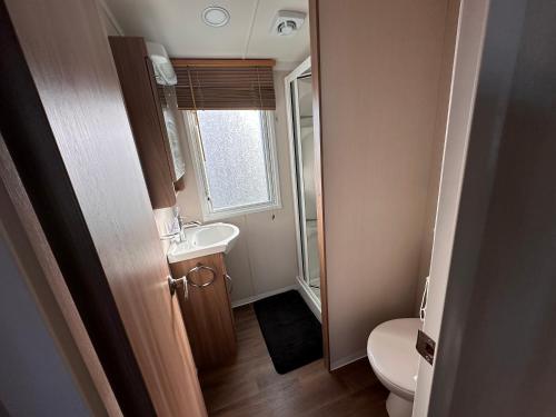 a small bathroom with a toilet and a sink at Ranworth - Haven Holiday Park in Caister-on-Sea