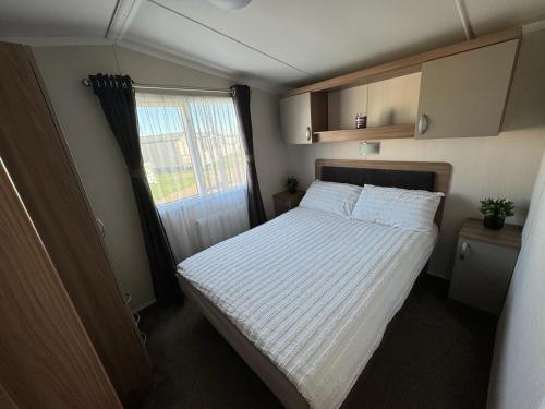 a small bedroom with a bed and a window at Ranworth - Haven Holiday Park in Caister-on-Sea