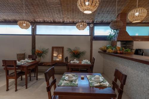 a dining room with tables and chairs in a room at Pousada Cajueiro Trancoso in Trancoso