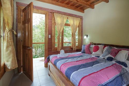 a bedroom with a bed and a window at Casa del Rio en MINDO in Mindo