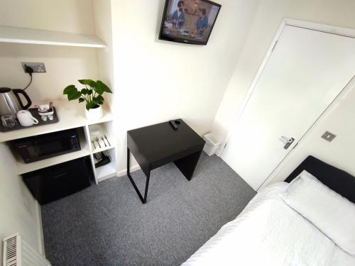 a small bedroom with a bed and a desk at Osney Single Studio only for one adult in Oxford