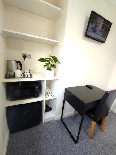 a room with a desk and a table with a plant at Osney Single Studio only for one adult in Oxford
