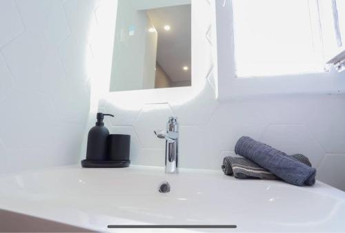 um lavatório de casa de banho com um dispensador de sabão e um espelho em La Perle du Lac 3* - VUE LAC em Annecy