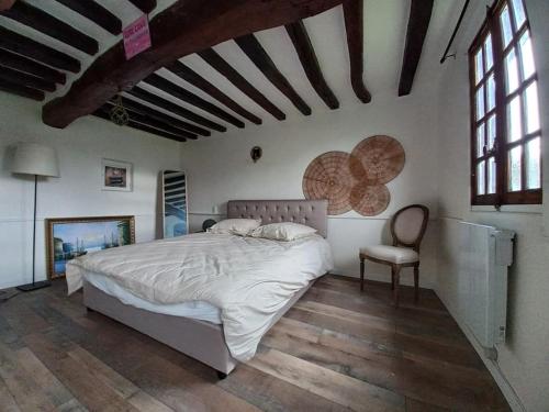 1 dormitorio con 1 cama grande y 1 silla en Golf&Love in Normandy, en Sainte-Opportune-du-Bosc