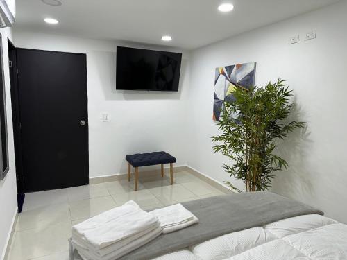 a bedroom with a bed and a tv on the wall at 33 HOTEL BOUTIQUE in Medellín