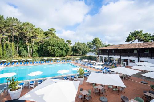 un hôtel avec un billard, des tables et des chaises dans l'établissement Villages Clubs du Soleil - SOUSTONS, à Soustons