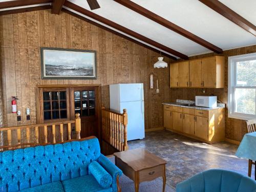 uma sala de estar com um sofá azul e uma cozinha em Rustic Retreat em Lambton Shores