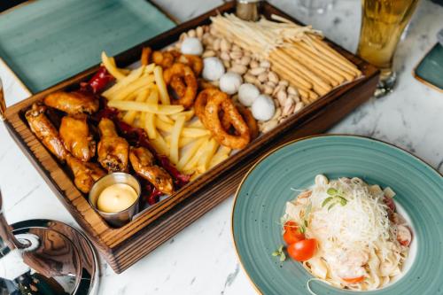 una bandeja de diferentes tipos de comida en una mesa en Sunrise Hotel, en Taldykorgan