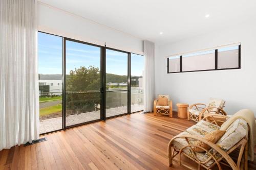 a living room with white walls and a large window at Dunes at Tomakin in Tomakin