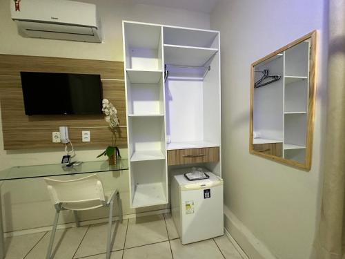 a room with a desk and a table with a computer at Hotel Aeroporto Montese Star in Fortaleza