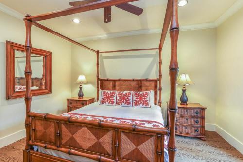 1 dormitorio con cama con dosel y espejo en Ground Floor Luxury Penthouse in Poipu Kai, en Koloa