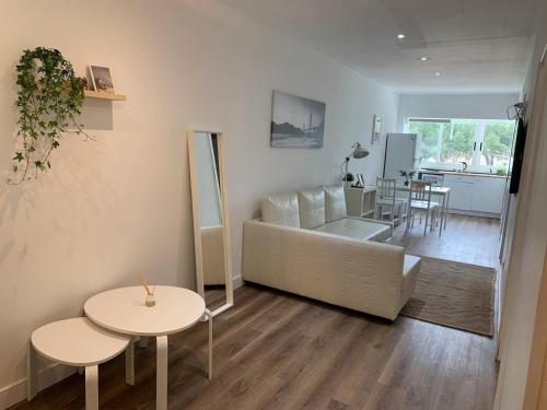 a living room with a white couch and two tables at SLEEPER LLUM in Las Corts