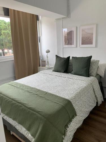 sypialnia z zielonym łóżkiem i oknem w obiekcie SLEEPER LLUM w mieście Las Corts