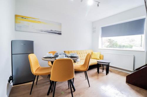 uma sala de jantar com mesa e cadeiras em 5 bed house with driveway! em Luton