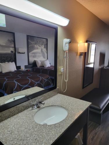 een hotelkamer met een wastafel en een bed bij Super 8 by Wyndham Sullivan in Sullivan